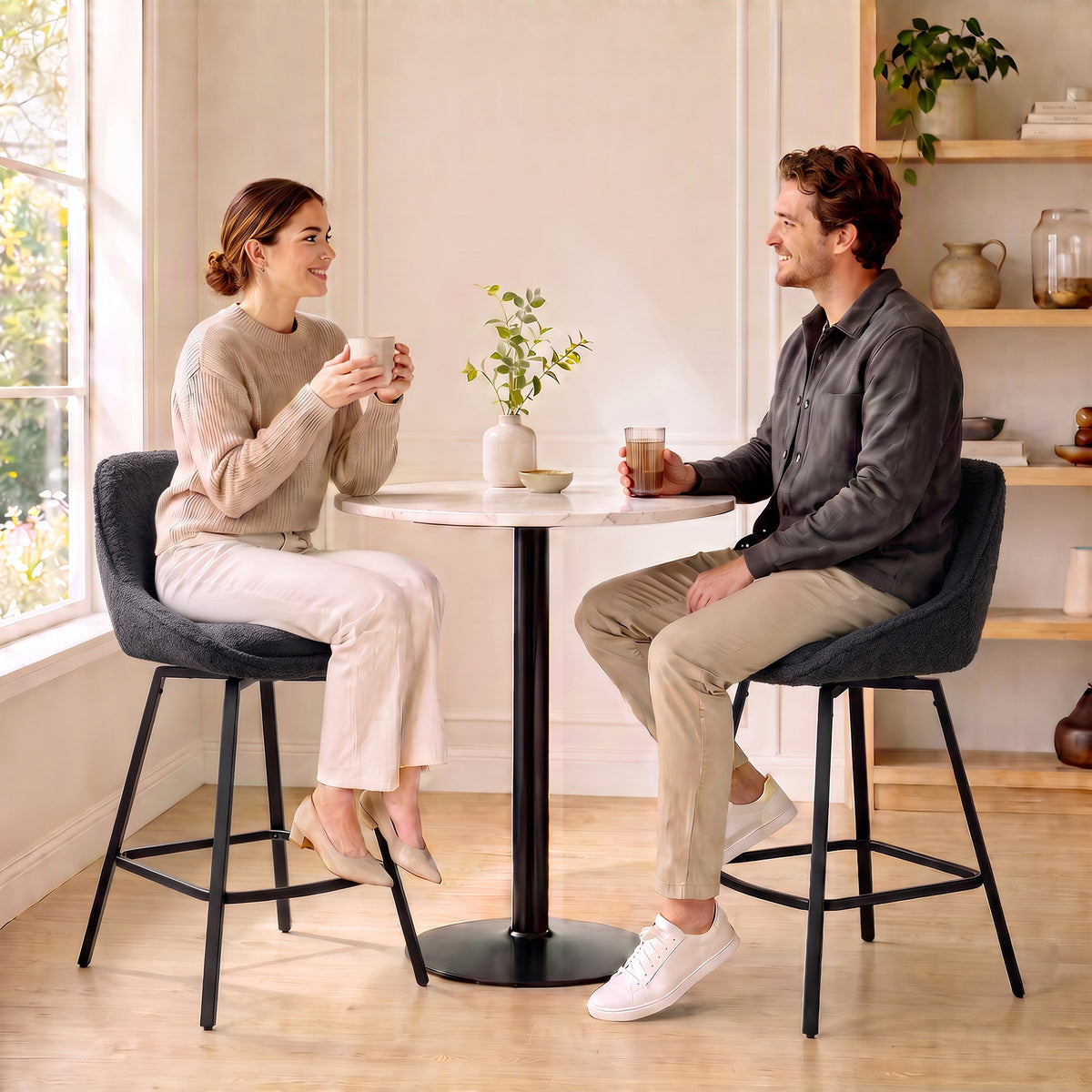 Two black swivel counter-height bar stools with curved seats and ergonomic backrests
