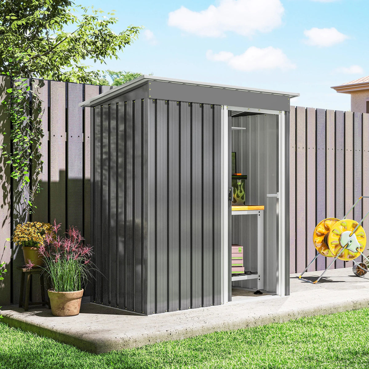 Light grey metal garden storage shed with closed sliding door and sloped roof