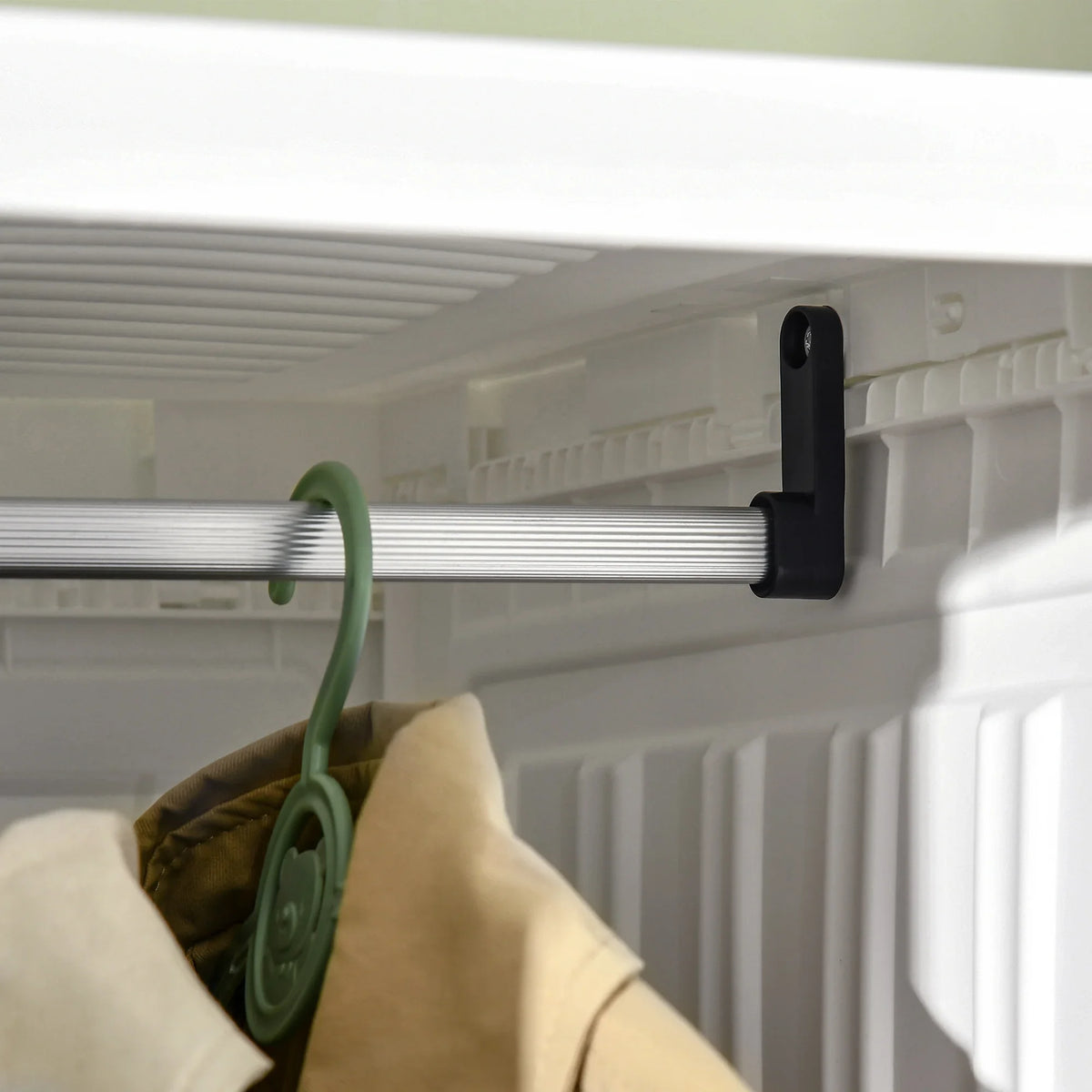 White wardrobe hanging rod with beige garment on a hook inside open cube.