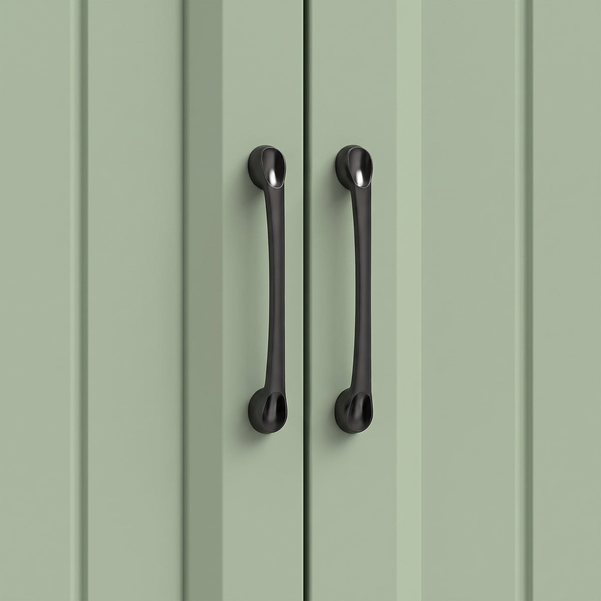 Sage green cabinet door with two black curved handles