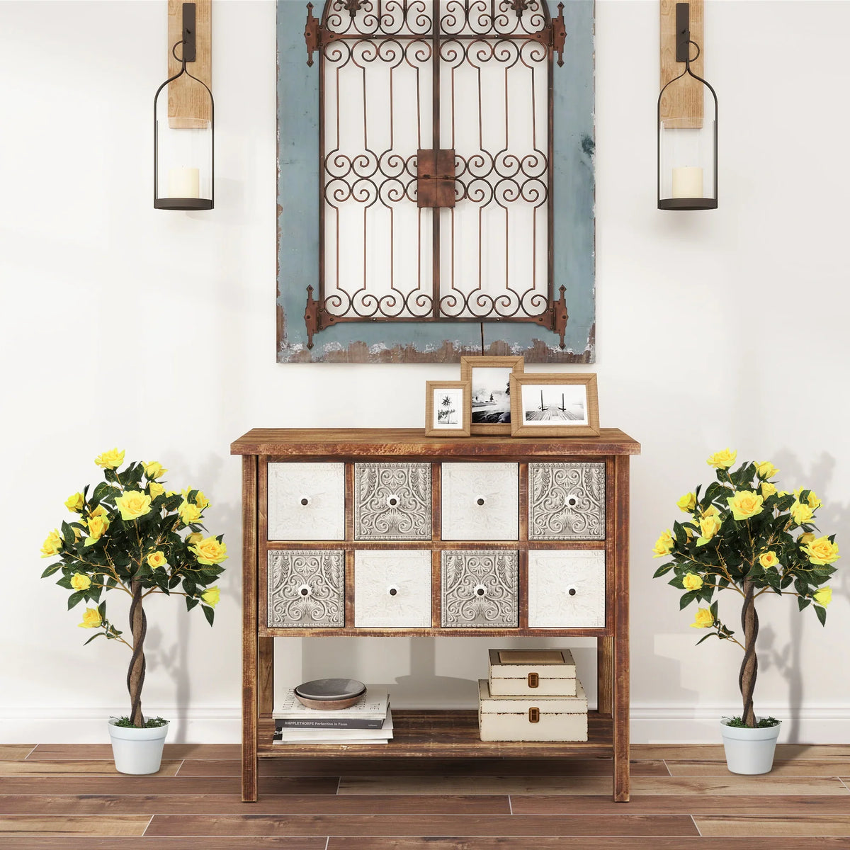 Two artificial yellow rose pots with brown trunks in white planters on a wooden floor