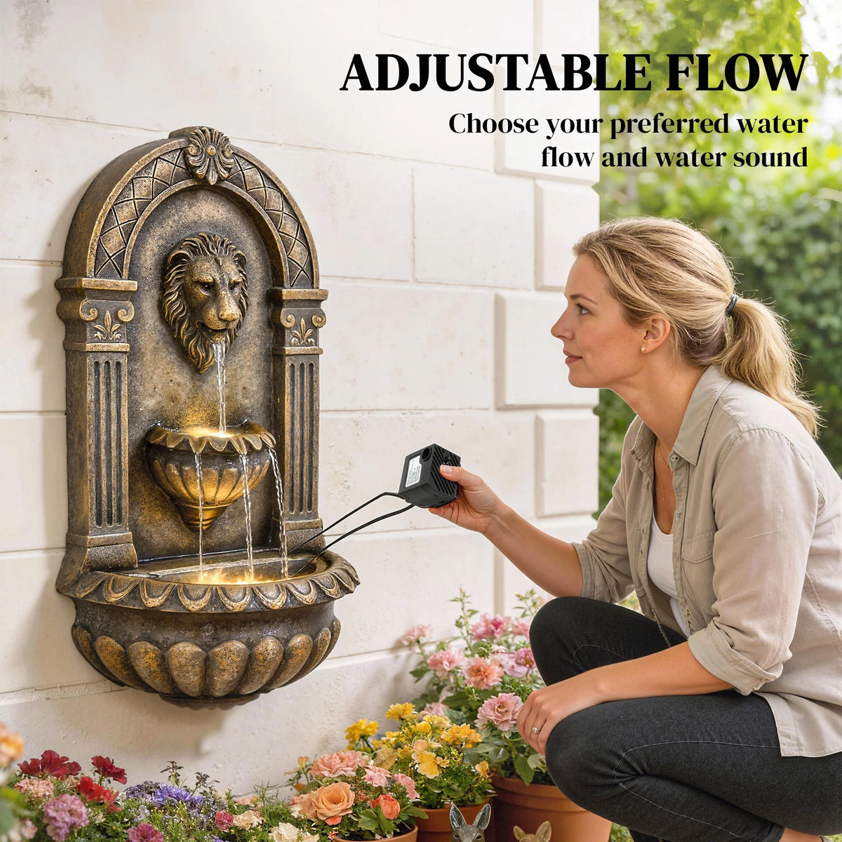 Wall-mounted lion-head water fountain with warm LED glowing tiers, person holding controller