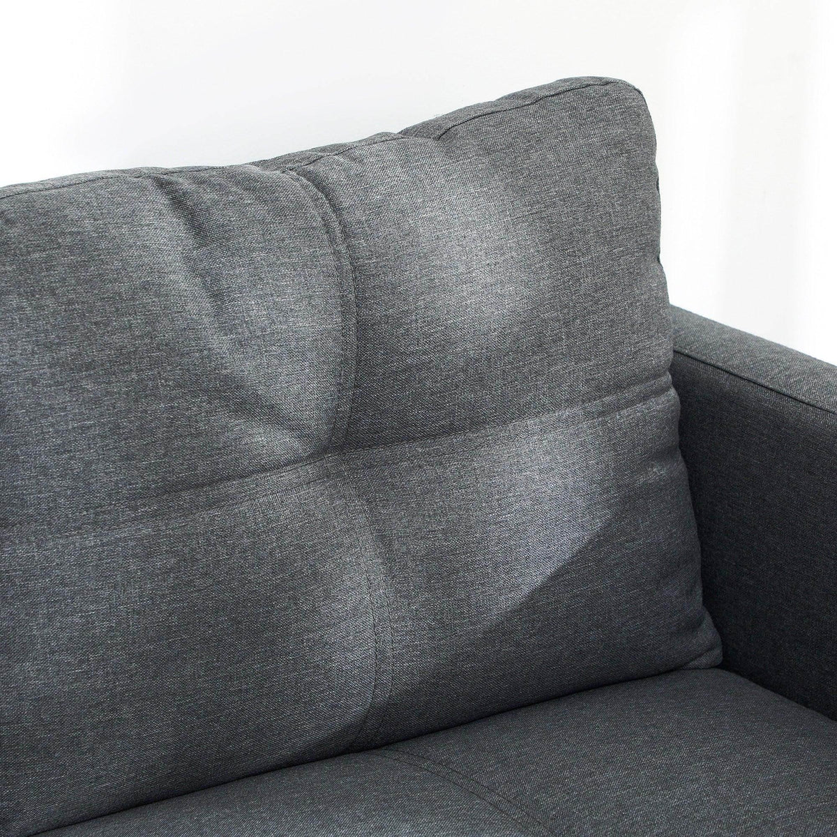 Gray loveseat sofa corner with thick back padding and smooth upholstered finish.