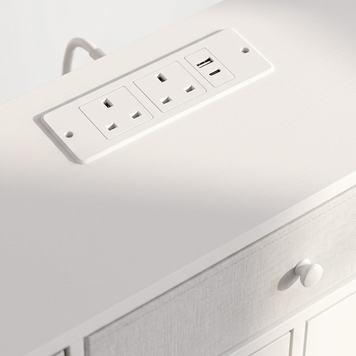 Close-up of white built-in power outlets on the dresser top with multiple sockets