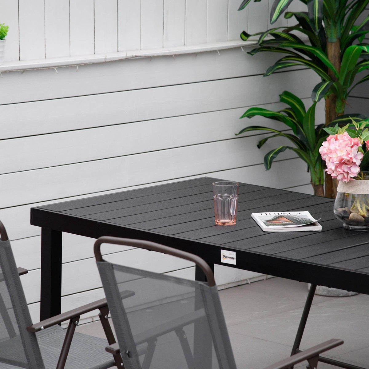 Black faux-wood effect tabletop with side edge and open leg frame for outdoor dining.