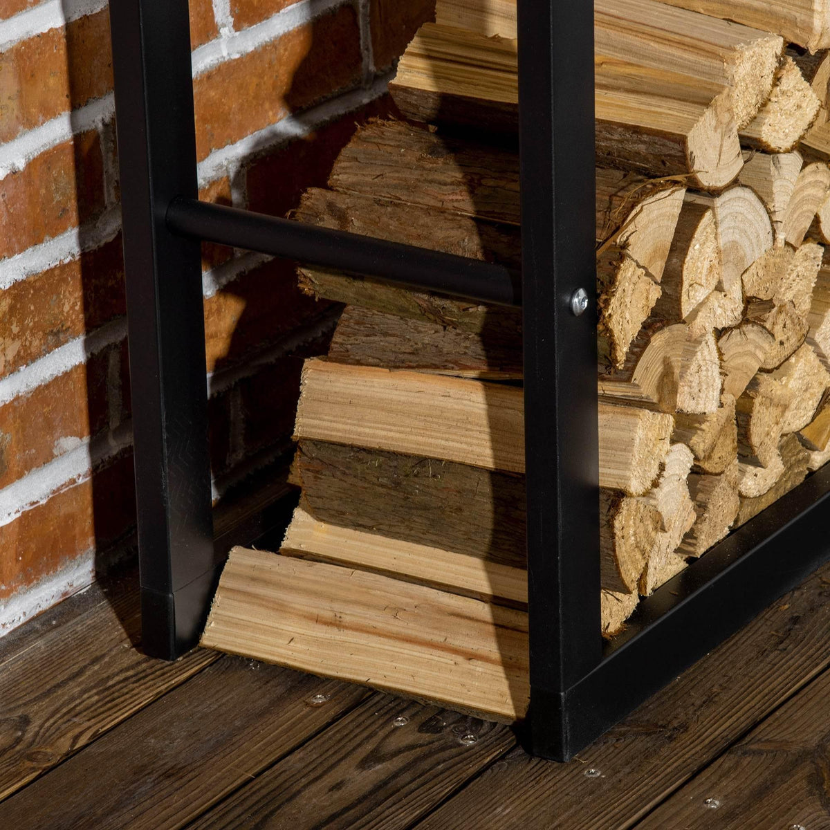 Black metal firewood rack with logs stacked on bottom shelf and side panels