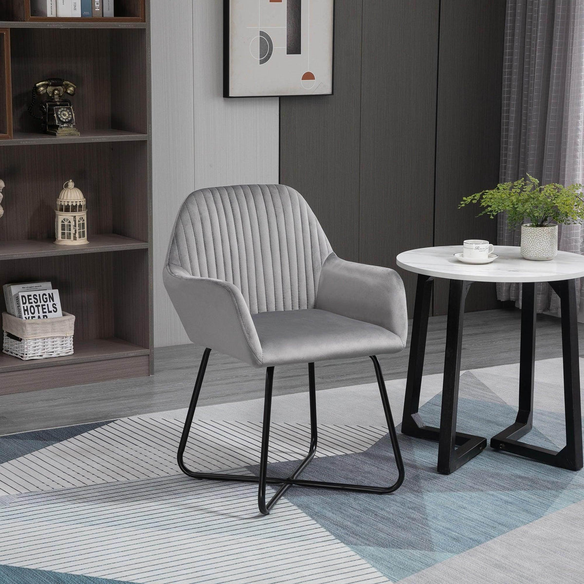Grey velvet-feel lounge armchair with channel tufted back and rounded arms, black sled legs