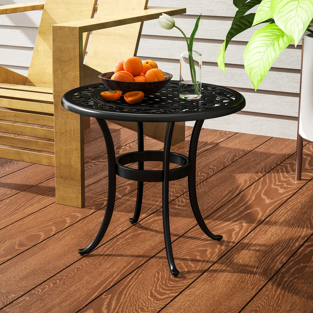 Black round cast aluminum patio end table with perforated lattice top and curved frame