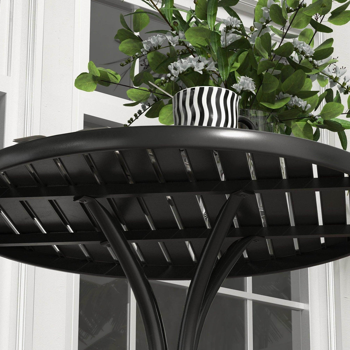 Black slatted round tabletop with curved steel support legs