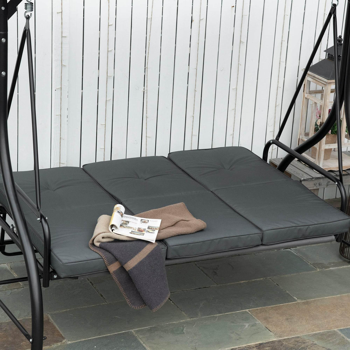 Dark grey three-seat swing bed cushion set with canopy supports and curved arm frame