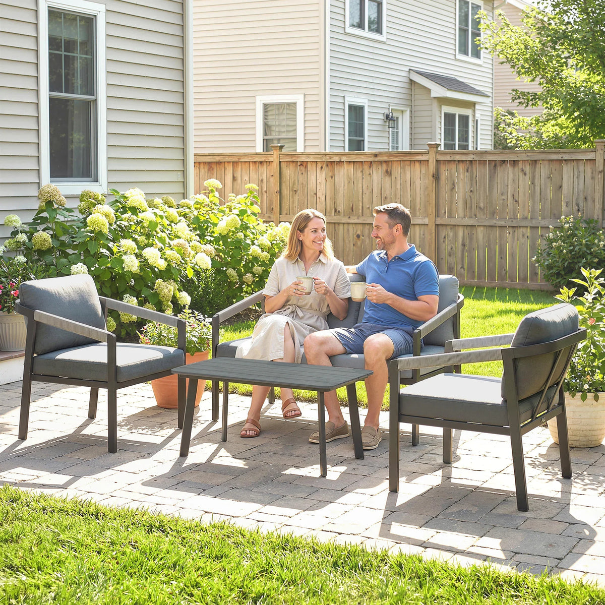 Outdoor patio seating set with gray cushions: loveseat and armchairs around a slatted table