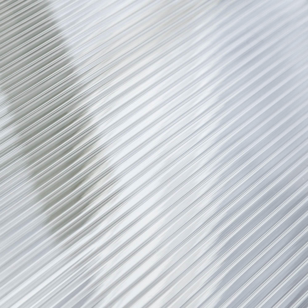 Clear polycarbonate canopy panel with fine ridges, close-up