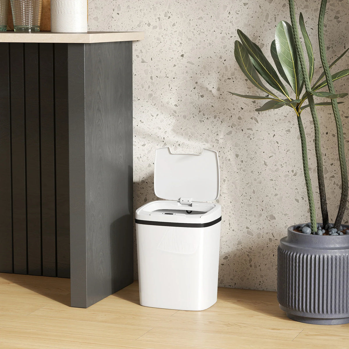 White touchless sensor kitchen bin with closed lid on light wood floor
