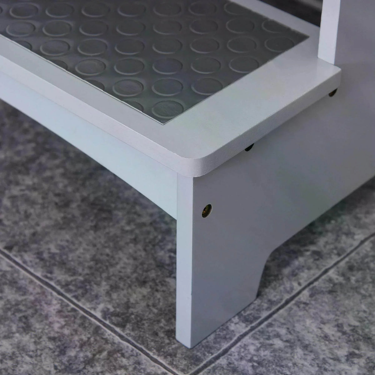 Grey wooden step stool corner with textured non-slip step platform