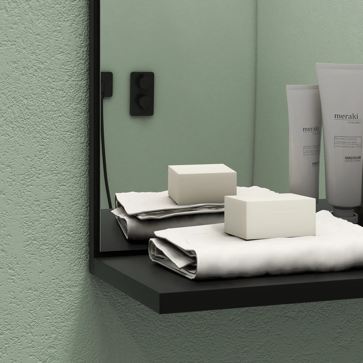 Bathroom mirror shelf with black backing holding toiletries and boxes
