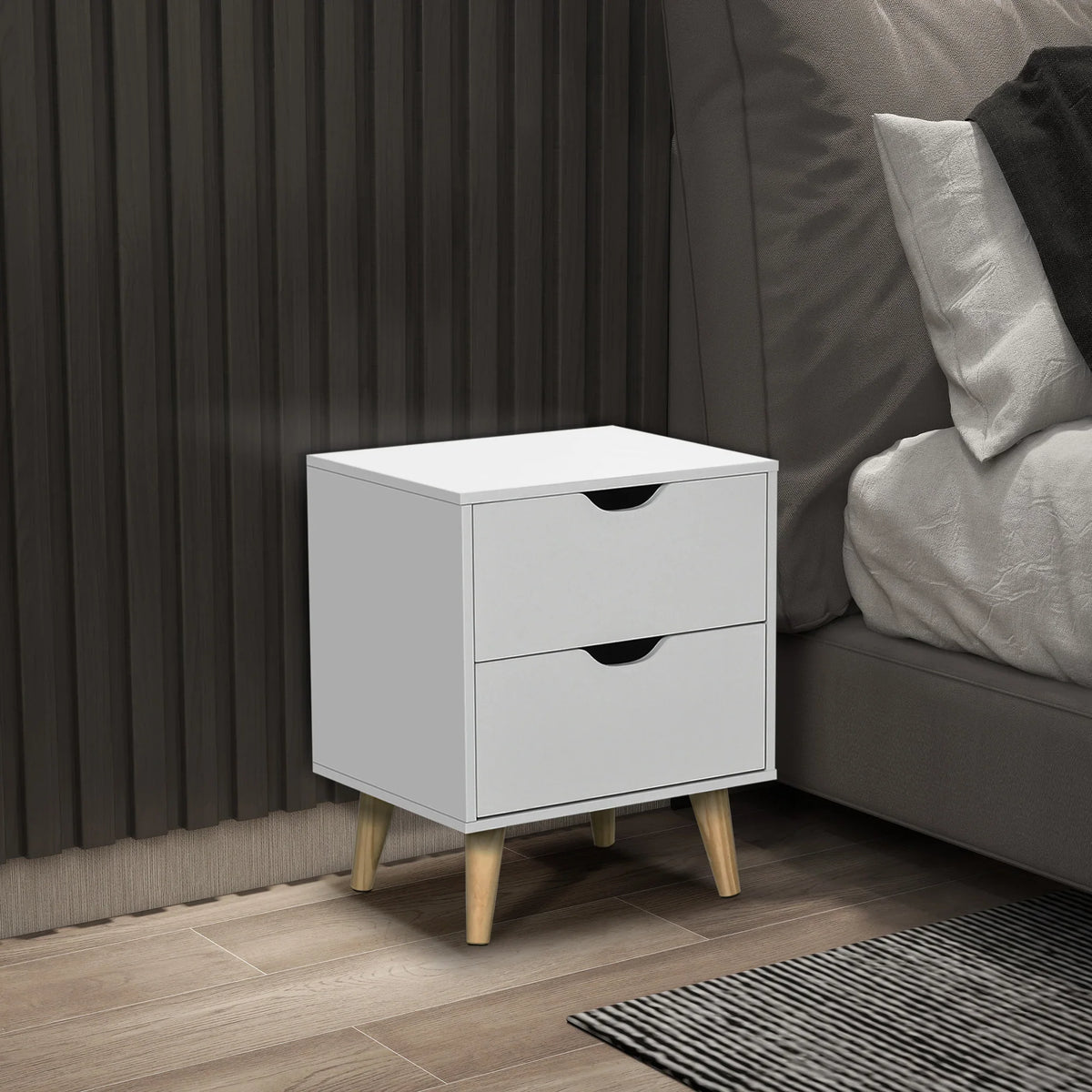 White bedside cabinet with two drawers and black curved cut-out handles, on pine legs.