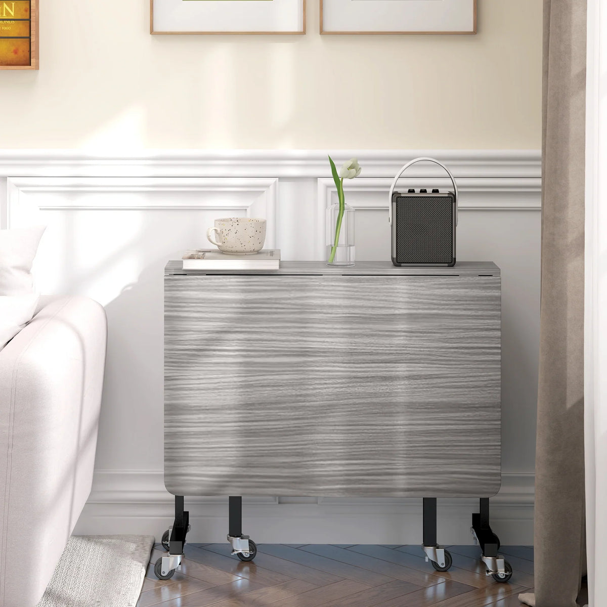 Folded grey drop-leaf dining table on wheels, compact storage for small spaces