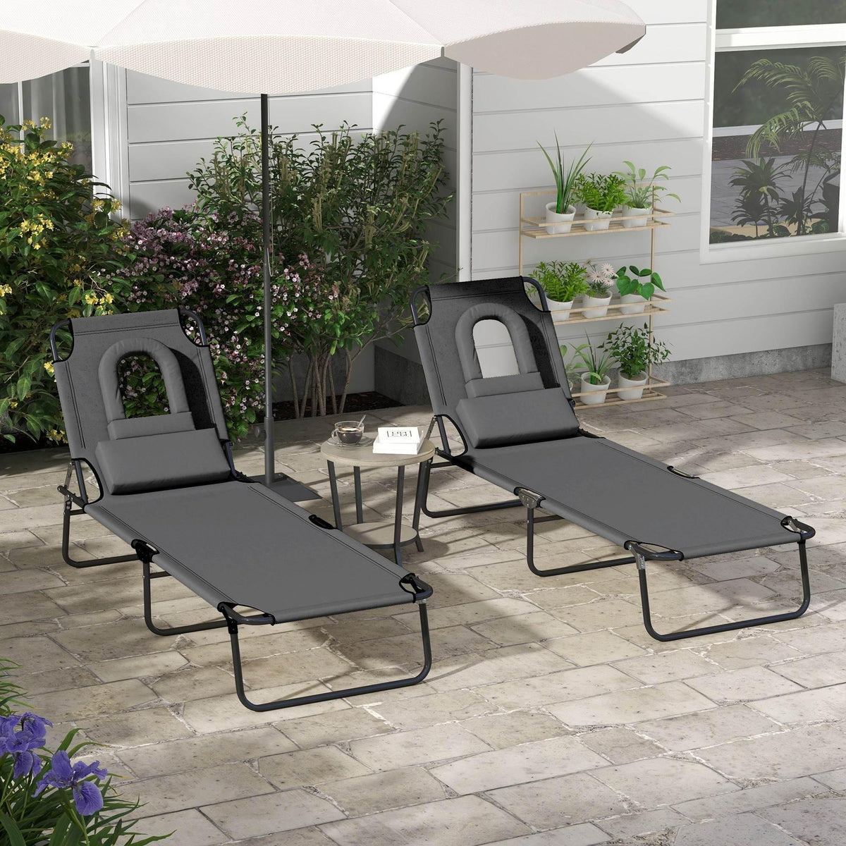 Dark grey adjustable sun lounger duo with padded face hole, two recliners outdoors