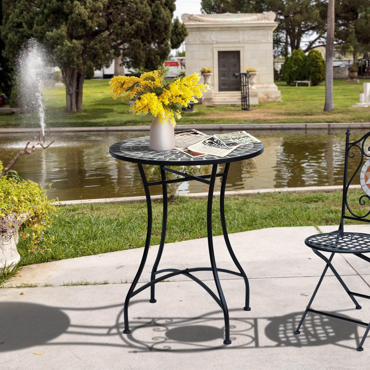 Round bistro table with grey mosaic tile top and black metal legs, outdoor style