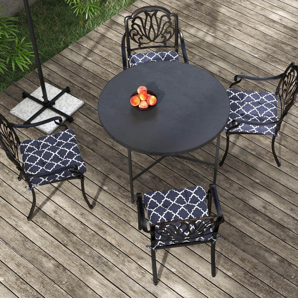 Four-piece navy blue cushion set with white geometric print on patio chairs