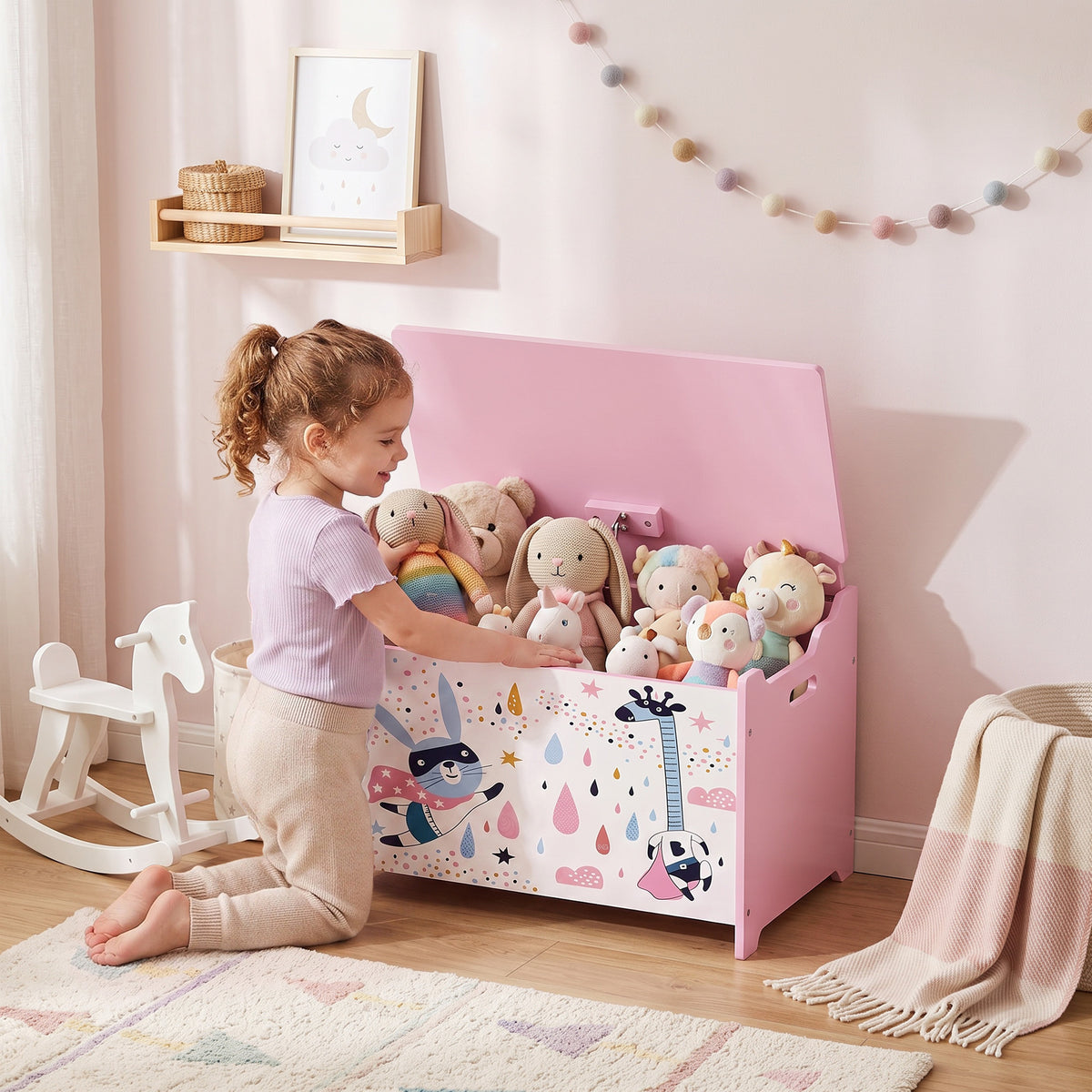 Pink flip-top wooden toy chest open, showing stuffed animals inside