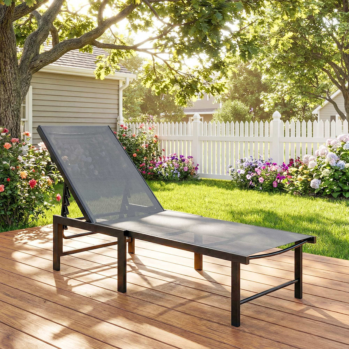 Grey adjustable sun lounger with mesh-textiline seat and reclining back on a patio