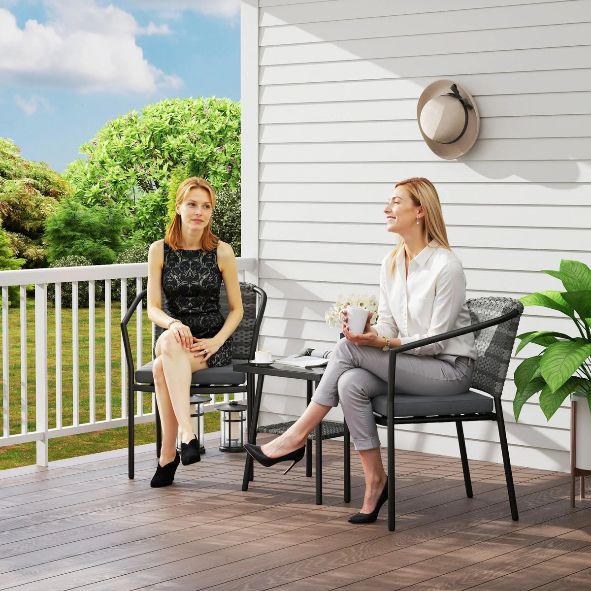 Outdoor grey rattan bistro set with glass-top table and two cushioned chairs