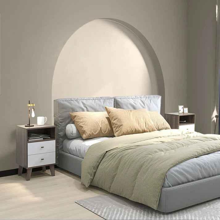 Modern gray upholstered bed with beige pillows, olive duvet, and matching nightstands in minimalist bedroom
