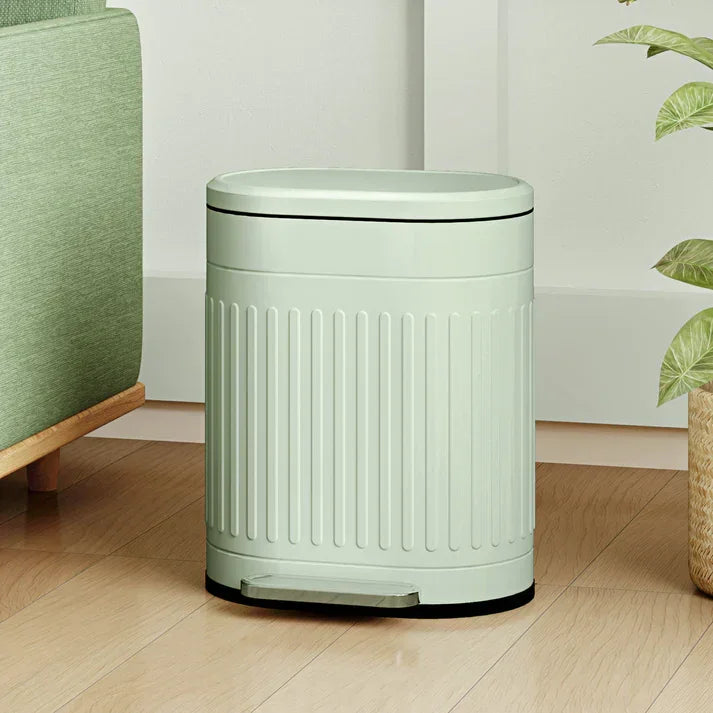 Mint green ribbed trash can with foot pedal in modern home setting
