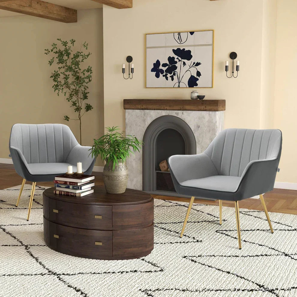 Modern gray velvet armchairs with gold legs, round wooden coffee table, and fireplace in cozy living room
