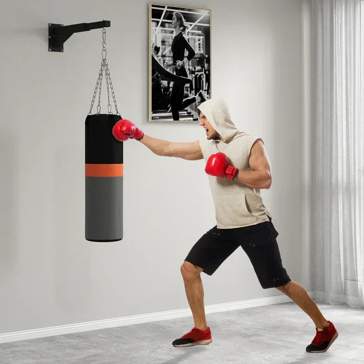 Man boxing with wall-mounted punching bag, red gloves, home gym setup
