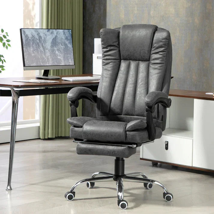 Grey leather office chair with footrest, adjustable arms, and chrome base in modern home office setup