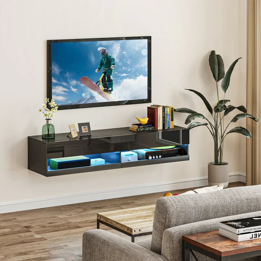 Modern black floating TV stand with LED lighting, holding media devices and decor in a cozy living room.