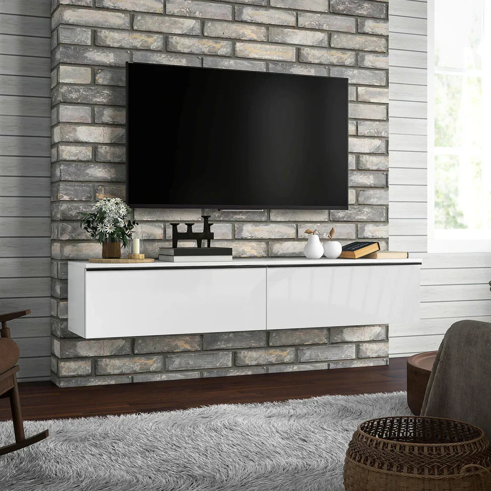 Modern living room with wall-mounted TV, glossy white floating TV stand, brick accent wall, and home decor.