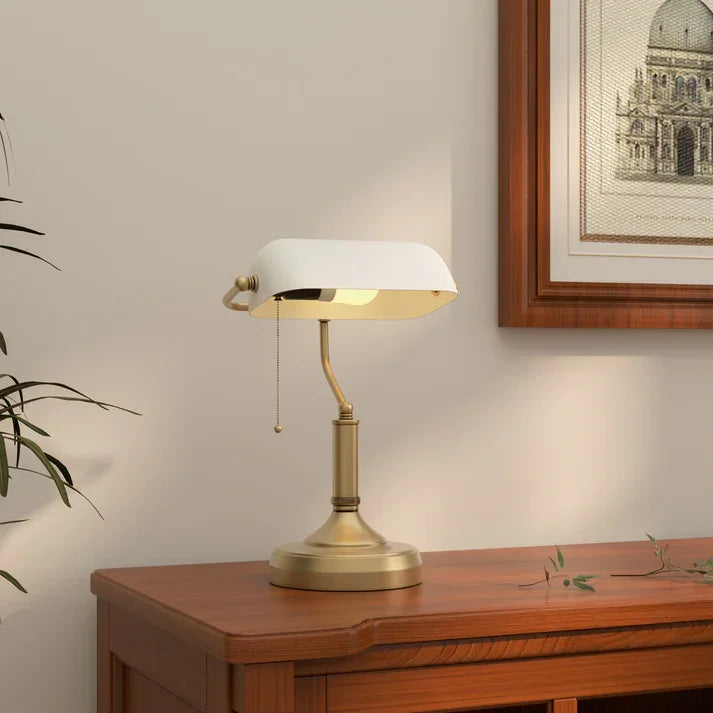 Brass banker's lamp with white shade on wooden desk, classic home office lighting