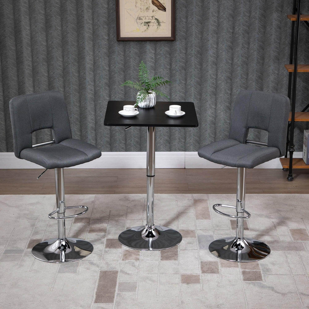 Modern adjustable black bar table with two grey swivel stools in a stylish home setting