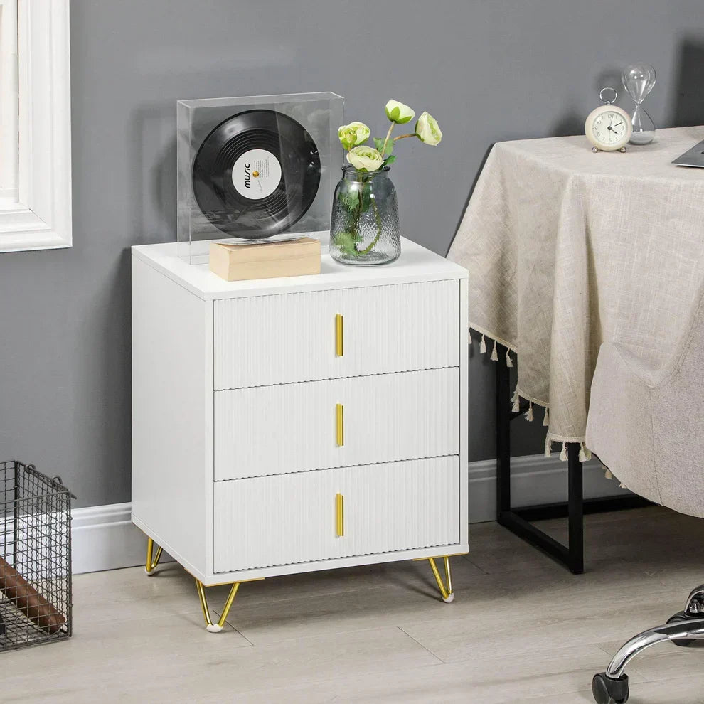 White 3-drawer nightstand with gold handles and legs, styled with vinyl record and flowers in modern home setting