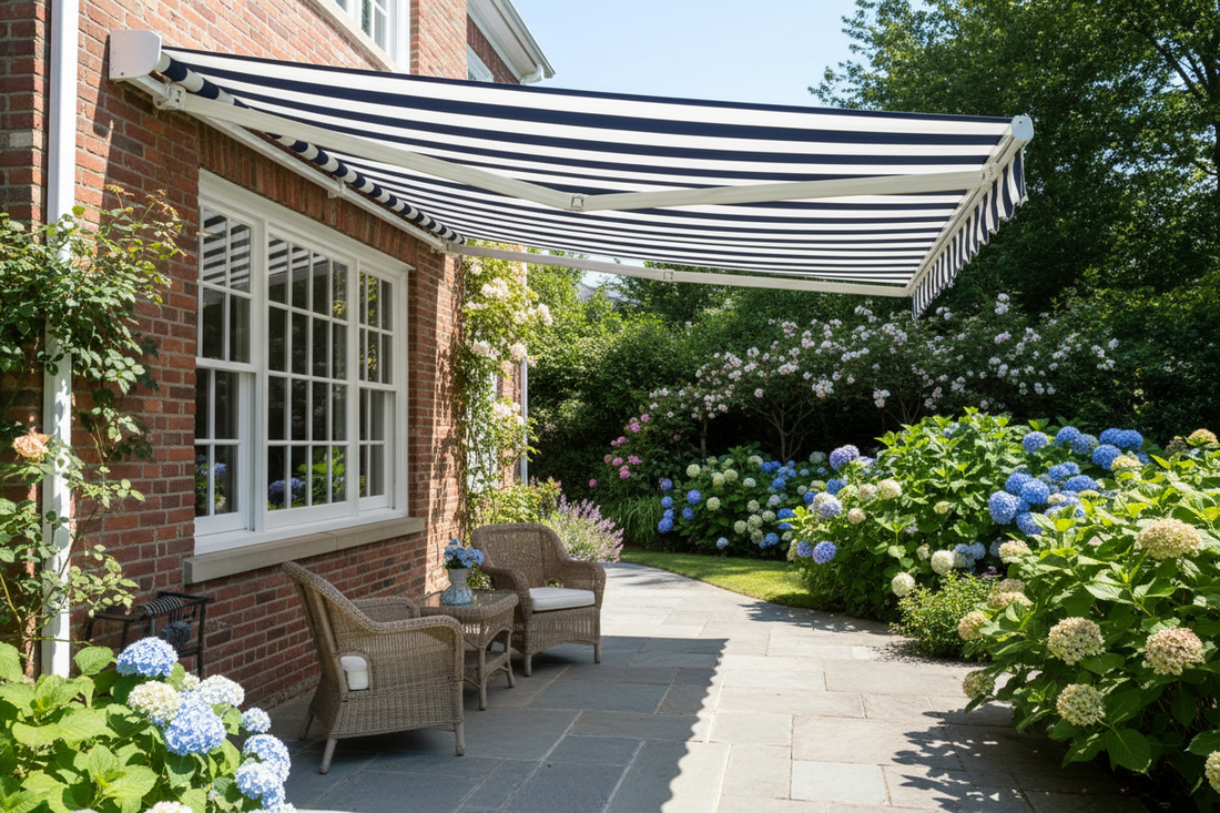 Striped patio awning over wicker chairs on brick home patio with hydrangea garden