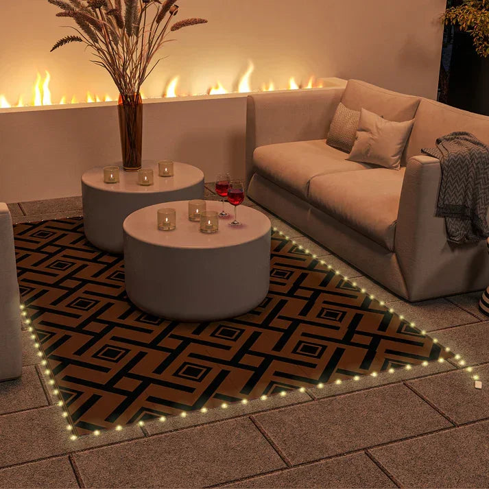 Outdoor patio rug with geometric pattern, LED lights, modern sofa, and coffee tables near fireplace