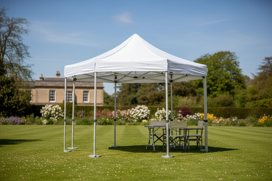 White pop up gazebo with chairs on green lawn in a garden setting