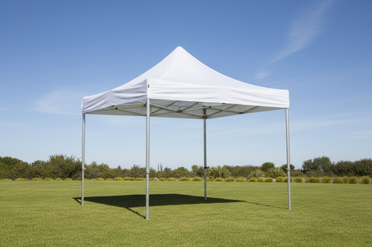 White pop-up gazebo tent on green grass outdoors with clear blue sky
