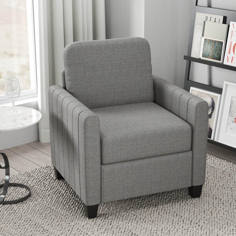 Gray fabric armchair with tufted sides, placed on textured rug in modern living room setting