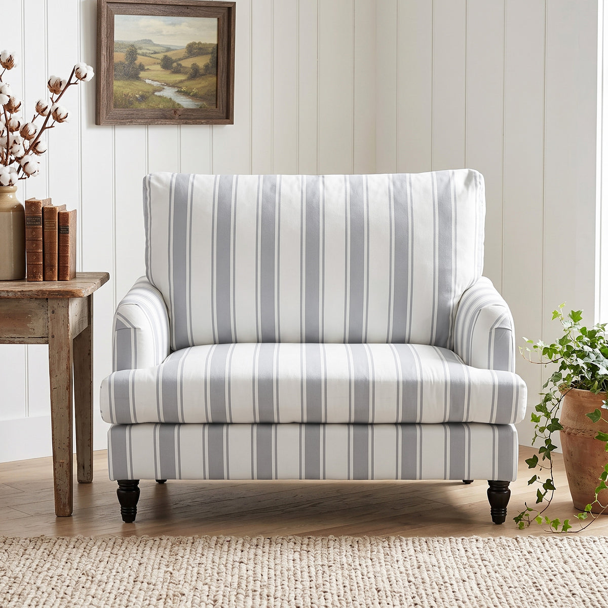 Grey striped velvet armchair with wide seat, supportive backrest, and dark turned legs