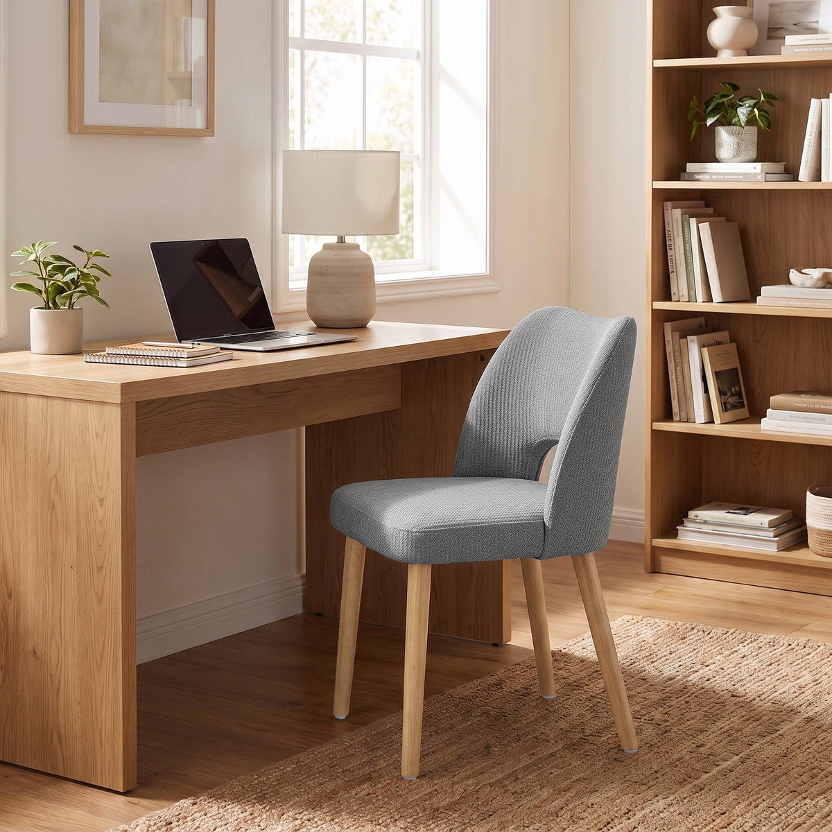 Grey chenille upholstered chair with curved back and light wood legs for dining
