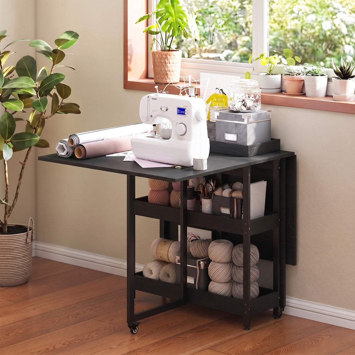 Black drop-leaf dining table with open shelves and rolling base
