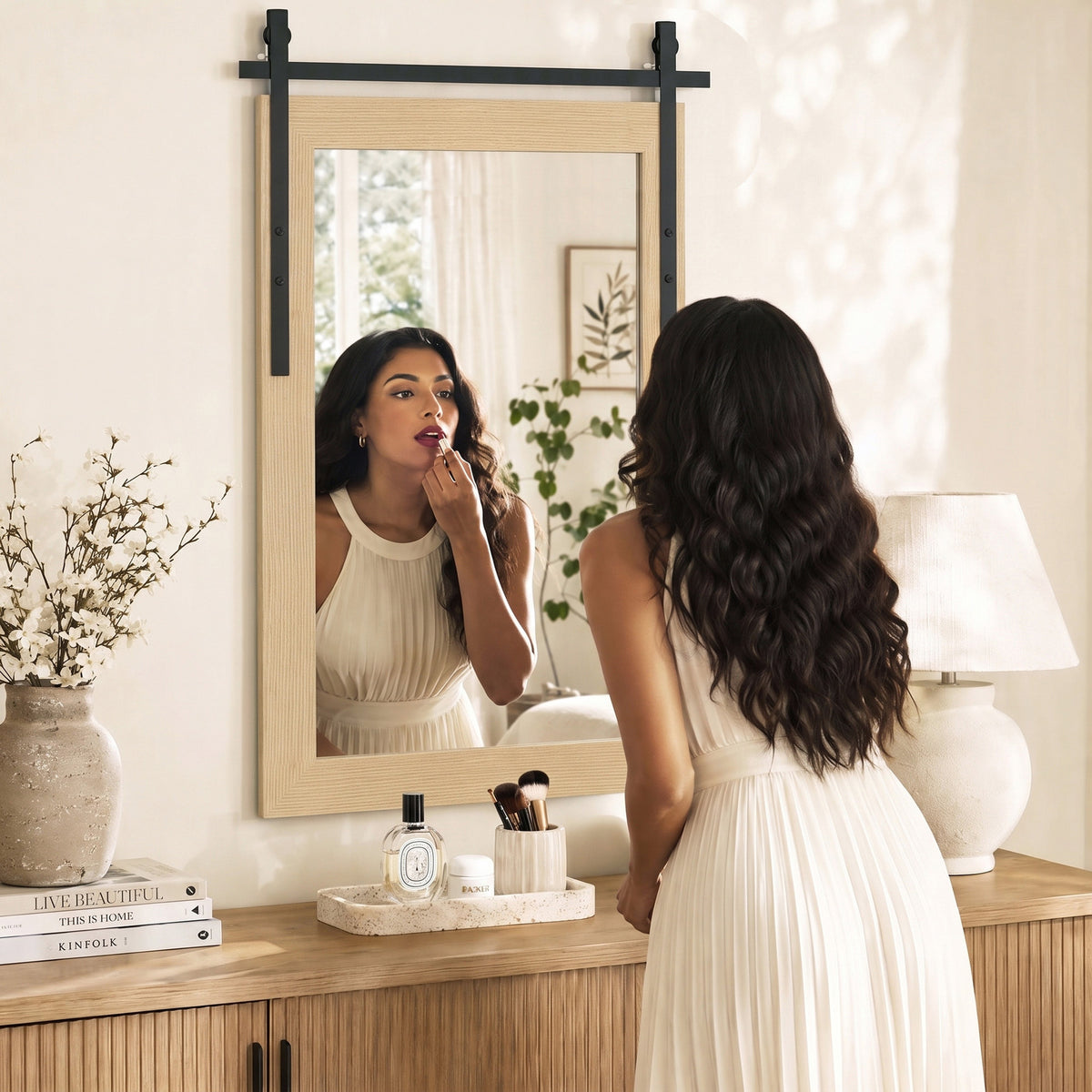 Rectangular wall mirror with light wood frame on vanity with black mounting bars