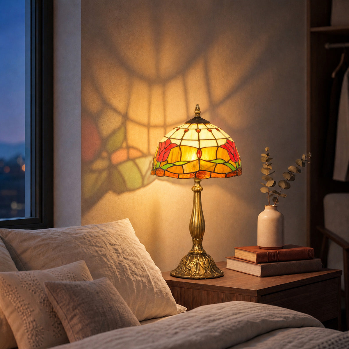 Tiffany stained glass table lamp with lit multicolor shade on bedside table