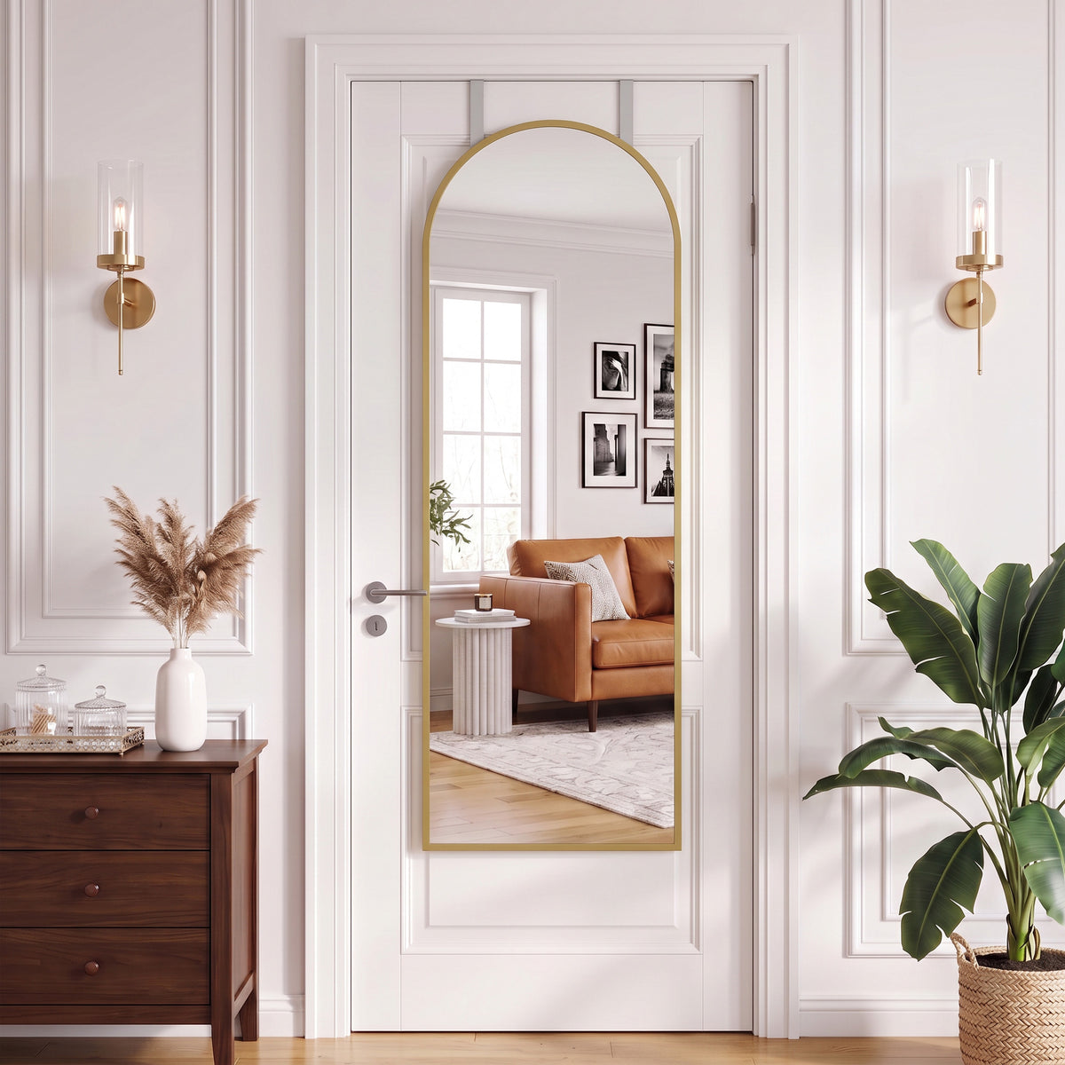 Arched full-length wall mirror with gold frame in a white door opening