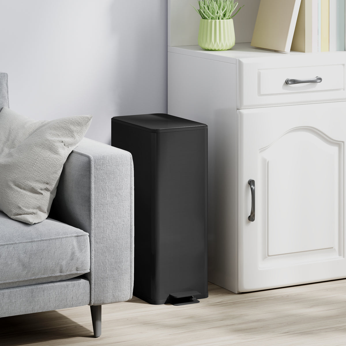 Black kitchen pedal trash can with soft-close lid and foot pedal, rectangular bin.