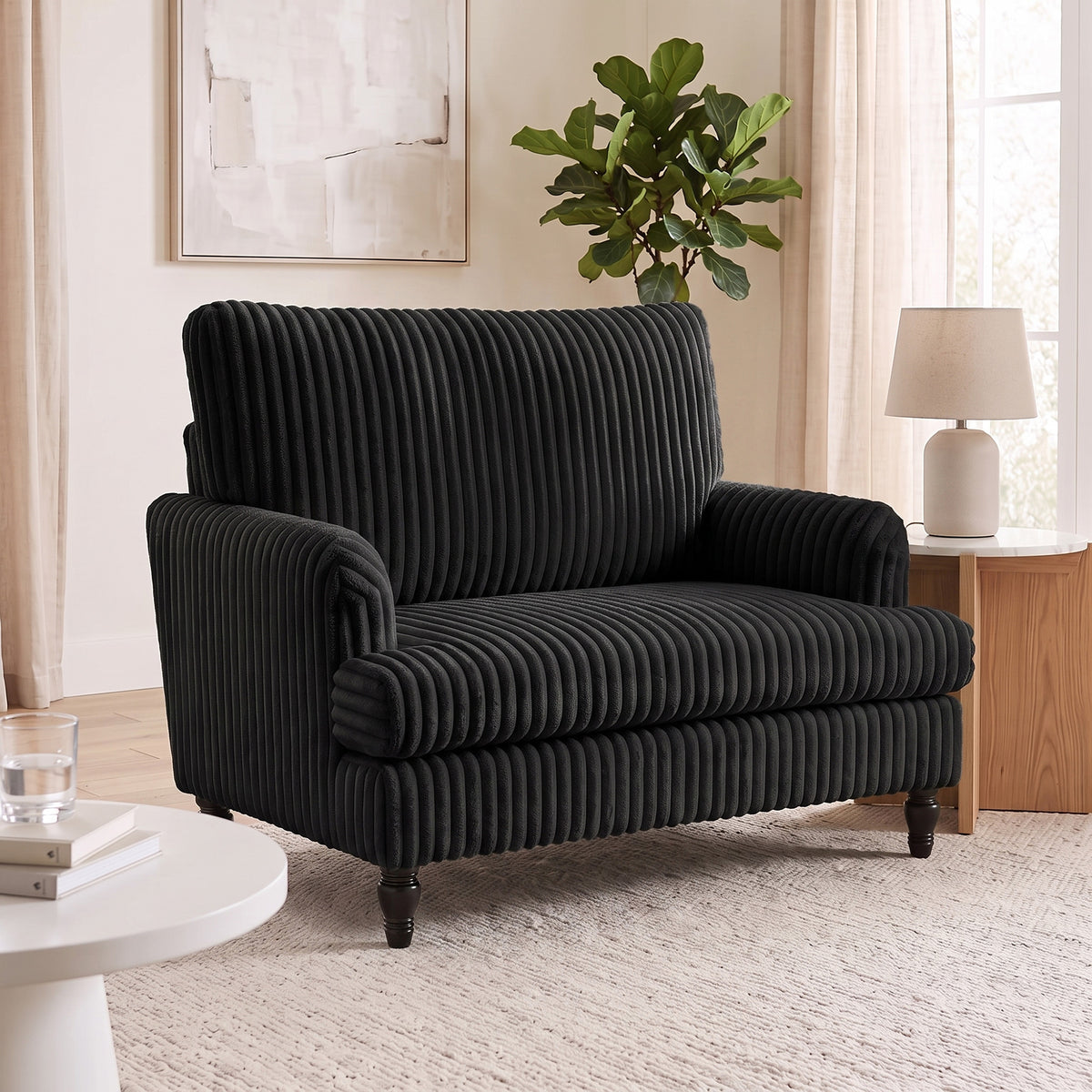 Black corduroy accent armchair with wide seat, rolled arms, ribbed texture